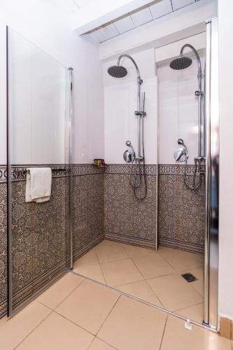 a bathroom with two shower stalls with tiled floors at Arabesque Arts & Residency in ‘Akko