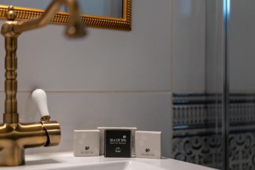 a bathroom sink with a faucet and two soap boxes at Arabesque Arts & Residency in ‘Akko