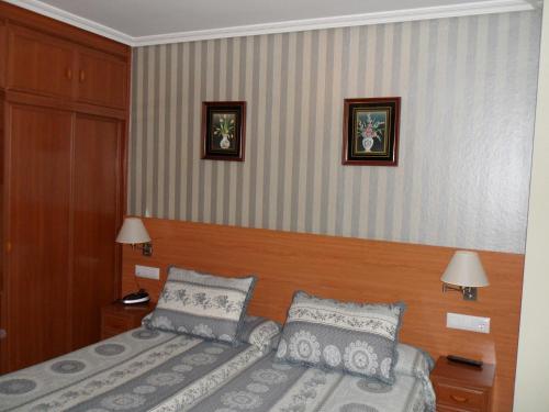 ein Schlafzimmer mit einem Bett und zwei Bildern an der Wand in der Unterkunft Hotel Alemar in Somo