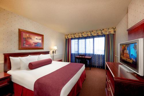 a hotel room with a bed and a flat screen tv at Four Queens Hotel and Casino in Las Vegas