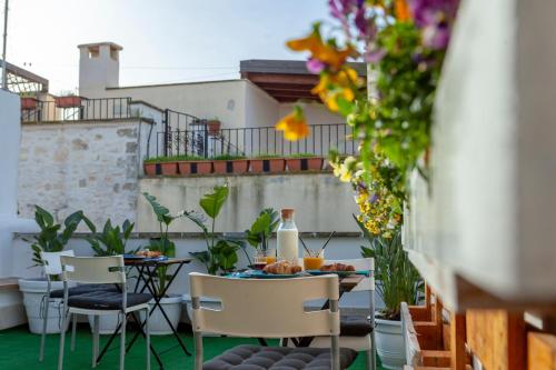 a table and chairs on a balcony with flowers at B&b Oltre l'Arco in Molfetta