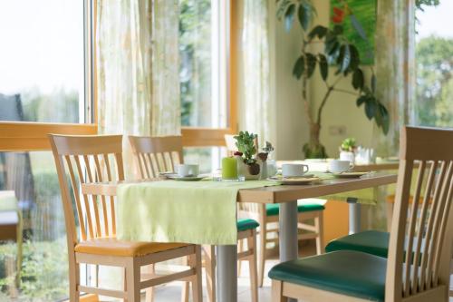 a dining room table with chairs and a table with a table cloth at Gasthaus-Pension Hofmann in Oberdachstetten