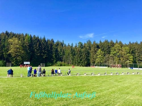 a group of people walking around a soccer field at Enjoy Hiking in Aufseß