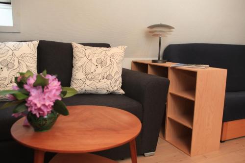 a living room with a couch and a table with a vase of flowers at Bed & Breakfast Horsens in Horsens