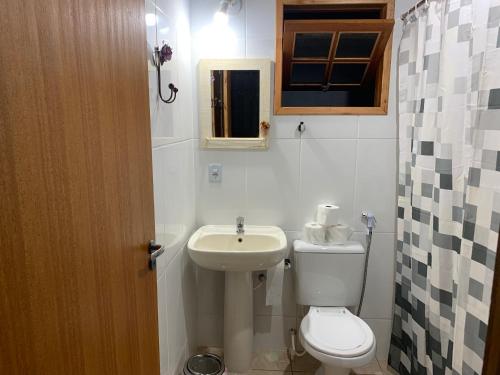 une salle de bain avec des toilettes blanches et un lavabo dans l'établissement Búzios Praia Rasa Casa 4, à Búzios