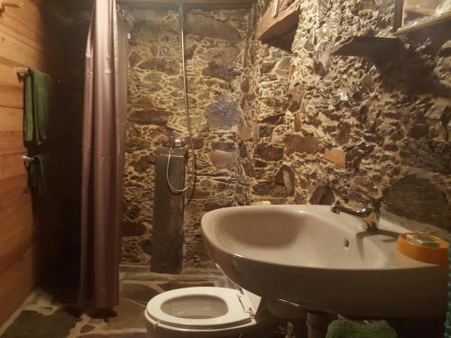 bagno in pietra con lavandino e servizi igienici di Casa da Carvalha a Lousã