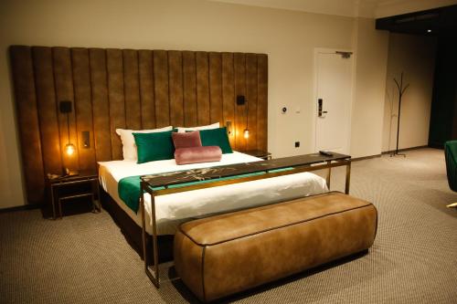 um quarto com uma cama grande e uma grande cabeceira. em Hotel Rubis em Ferizaj
