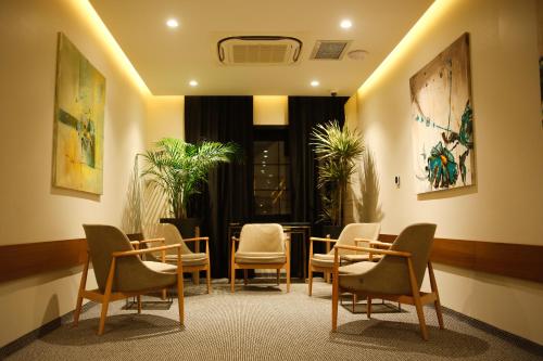 a waiting room with chairs and tables and paintings at Hotel Rubis in Ferizaj