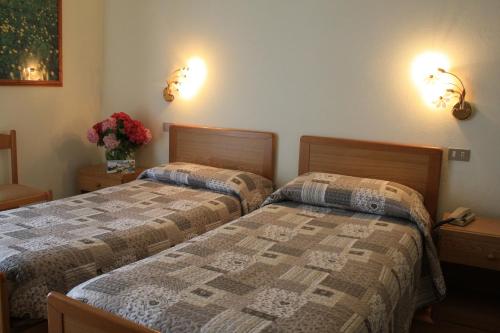 two beds sitting next to each other in a bedroom at Locanda Ridevert in Tione di Trento