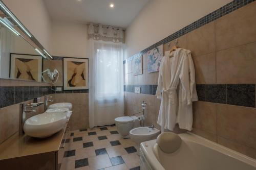 a bathroom with two sinks and a tub and two toilets at Residenza Hermitage in bedizzol