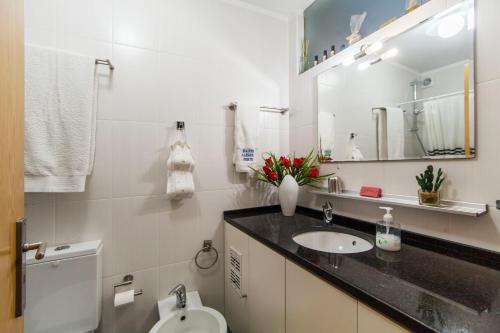 a bathroom with a sink and a toilet and a mirror at Bairro Alegre, Casa do Porto in Porto