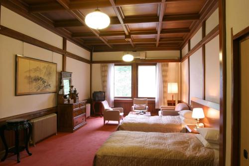 a hotel room with two beds and a living room at Nikko Kanaya Hotel in Nikko
