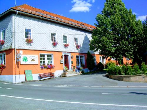 a orange building with a bench in front of it at Landgasthof "Zur Linde" in Dreba