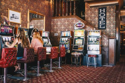 twee vrouwen zitten aan de speelautomaten in een casino bij Mizpah Hotel in Tonopah