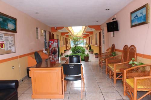 a restaurant with tables and chairs in a room at Hotel Isla Esmeralda in Cozumel