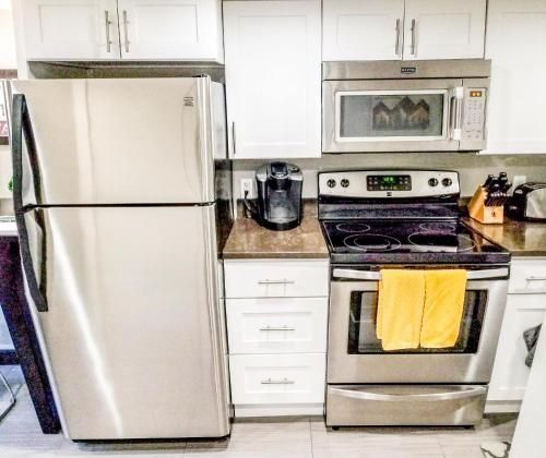 a kitchen with a stainless steel refrigerator and a microwave at Modern Seattle Oasis in Seattle