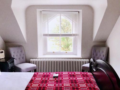 a bedroom with a table and two chairs and a window at Olif in Betws-y-coed