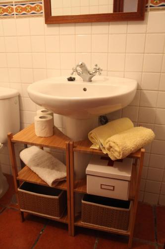 a bathroom with a sink and a shelf with towels at Casas La Torre in Isora