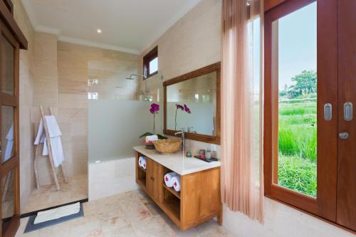 a bathroom with a sink and a mirror at Champaca Luxury Villas Ubud in Ubud