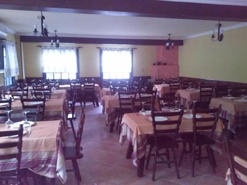 a dining room with tables and chairs and windows at Paradisiaco Umia in Meis