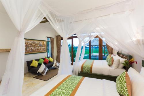 乌布Champaca Luxury Villas Ubud的带两张床和一张沙发的卧室