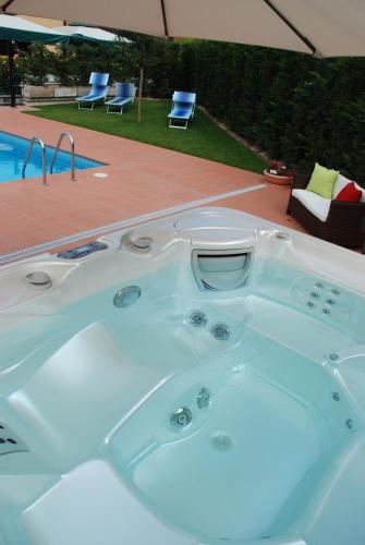 a bath tub sitting next to a swimming pool at Hotel La Pergola in Grezzana