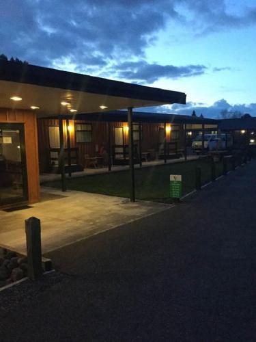 a lit up building with a parking lot at night at Waiouru Welcome Inn in Waiouru