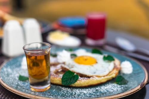 a plate with an egg and a glass of beer at Sunshine Resort Pokhara - Your Private Paradise in Pokhara