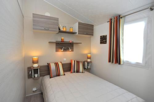 um quarto com uma cama num quarto com uma janela em Camping de Brouël em Ambon