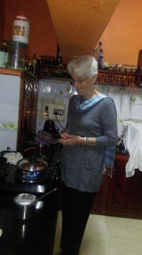 a woman standing in a kitchen next to a stove at Green View in Thekkady
