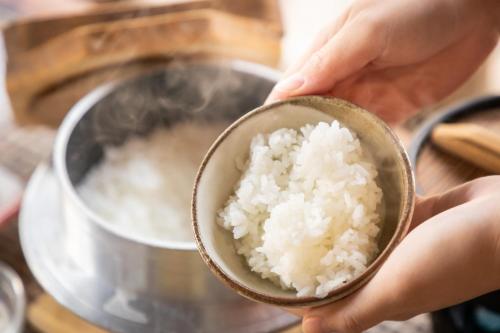 a person holding a small bowl of rice at Yufudake Ichibo no Yado Kirara in Yufuin