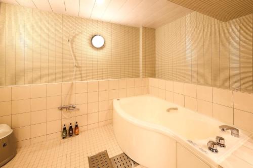 a white bathroom with a tub and a shower at Hotel Dio (Adult Only) in Osaka