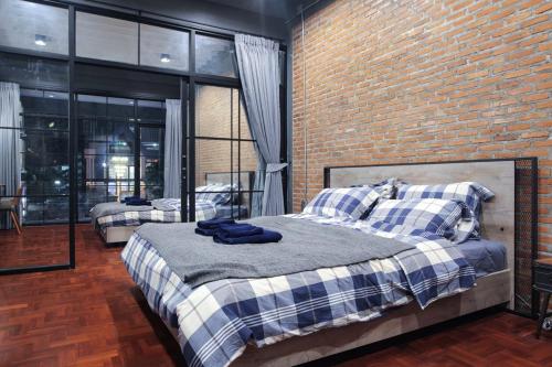 une chambre avec deux lits et un mur de briques dans l'établissement Signature coffee & bed, à Chiang Mai