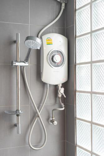 a shower with a shower head in a bathroom at Better Moon Guesthouse in Bangkok