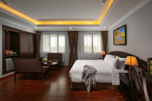 a hotel room with a bed and a table and chairs at Halais Hotel in Hanoi