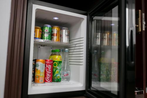 a refrigerator filled with lots of cans of soda at Halais Hotel in Hanoi