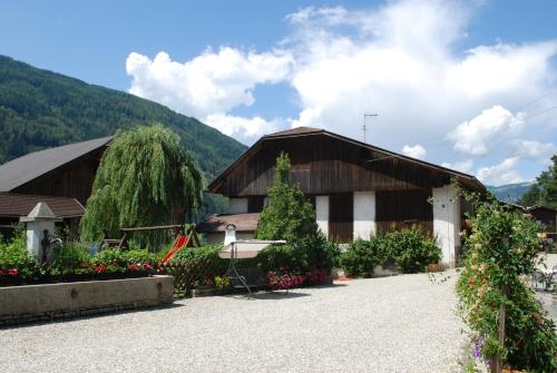 a building with a bunch of flowers in front of it at Residence Obermoarhof - Family Apartments with Pool & Playground in Vandoies