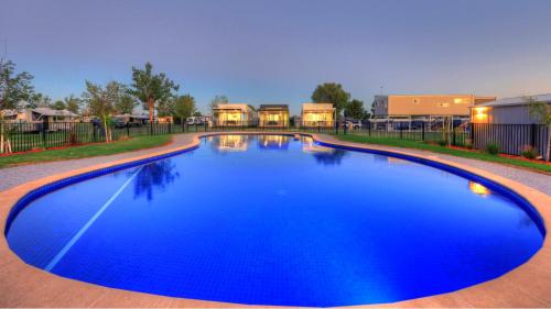 a swimming pool with a blue pool table and blue chairs at Tasman Holiday Parks - Lake Mulwala in Mulwala