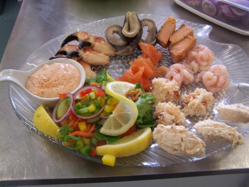 a plate of food with shrimp and vegetables on a table at Merkister Hotel in Harray