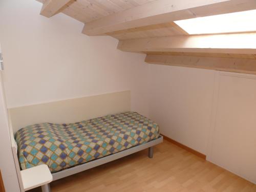 Dormitorio pequeño con cama en el ático en Villaggio Borgo dell'Ulivo, en Bibione