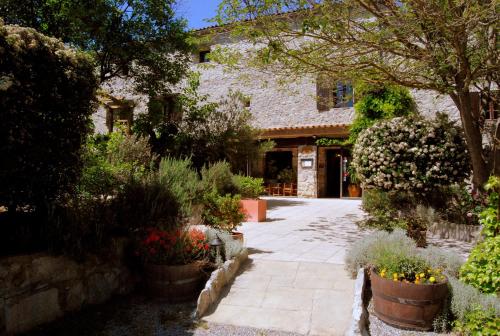 a garden with flowers and plants in front of a building at Hôtel Mas de l'Espaïre in Les Vans