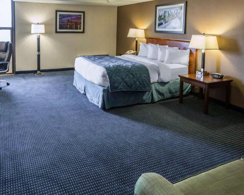 a hotel room with a bed and a table and lamps at Quality Inn Schaumburg - Chicago near the Mall in Schaumburg