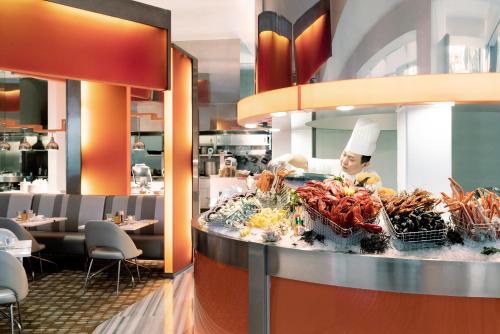a chef preparing food behind a counter in a restaurant at Shangri-La Singapore in Singapore