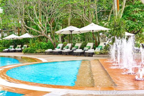 a swimming pool with chairs and a fountain at Shangri-La Singapore in Singapore