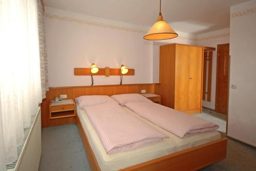A bed or beds in a room at Pension Riedlsperger