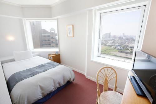 a bedroom with a bed and a large window at Hotel Kyocera in Kirishima