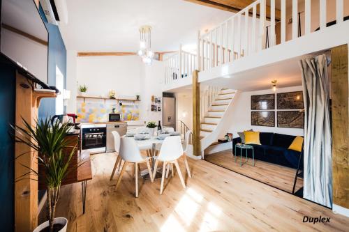 a kitchen and living room with a table and chairs and a staircase at Les Précieuses Suites & Spa I in Avignon