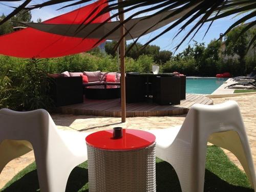 a red umbrella sitting on a table next to a pool at Villa W in Cassis