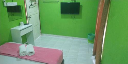 a green bathroom with a pink bench and a sink at Iz Village in Kuala Besut