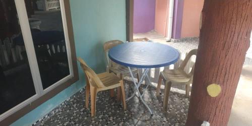 une table bleue et des chaises à côté d'une fenêtre dans l'établissement Iz Village, à Kampung Kuala Besut